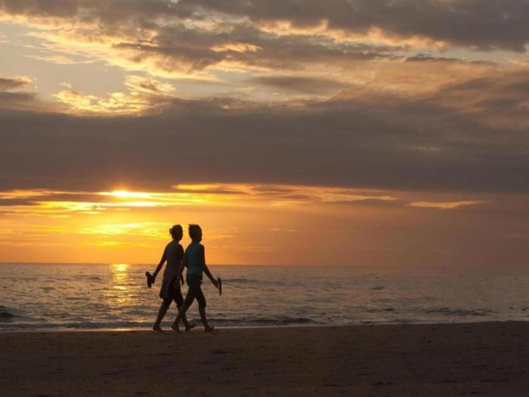 Wandelen op het strand bij zonsondergang