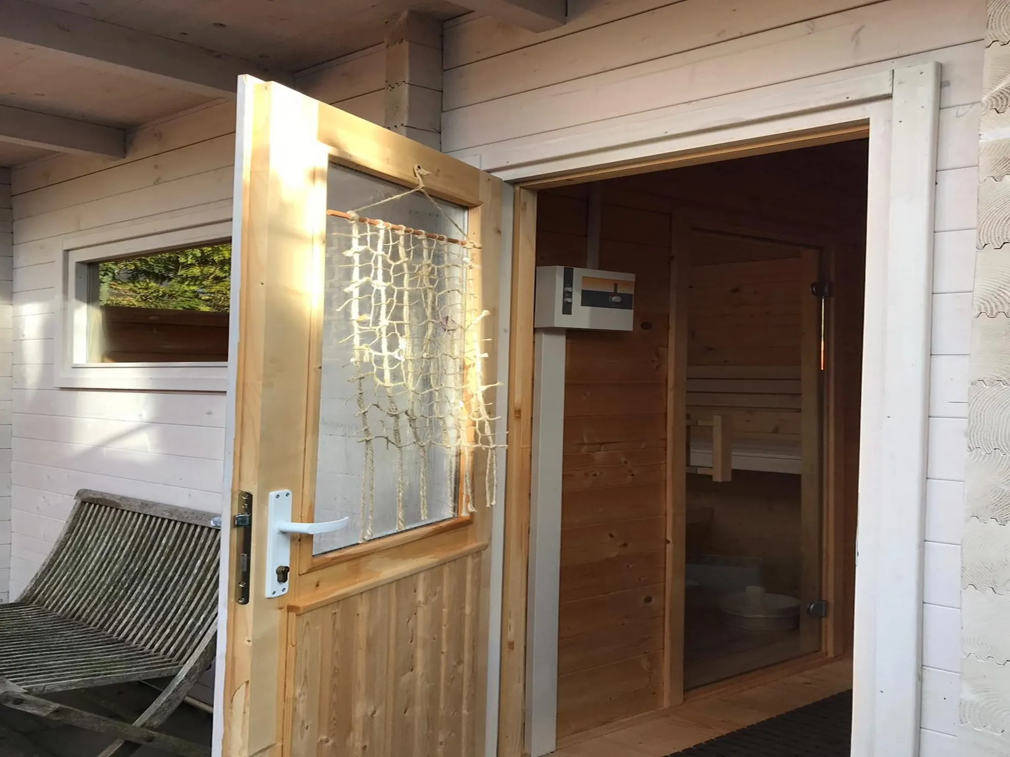 De sauna achter het huis, met de deur open