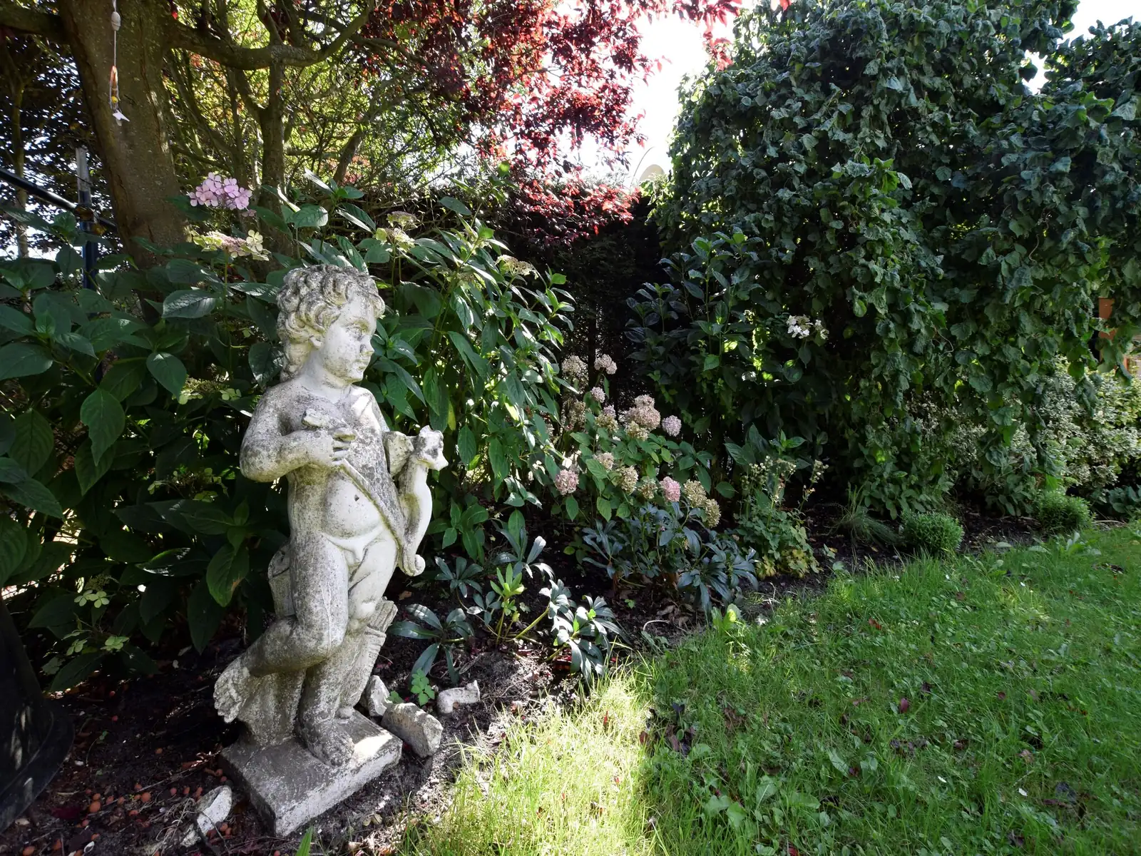 Een tuinbeeldje tussen de struiken